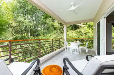 a balcony with chairs and a table with a view at Uvita Paradise , Walk to the Ballena Beach in Uvita