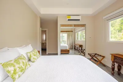 a bedroom with a large white bed with pillows at Uvita Paradise , Walk to the Ballena Beach in Uvita