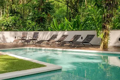 a group of chairs sitting next to a swimming pool at Uvita Paradise , Walk to the Ballena Beach in Uvita