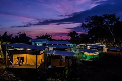 a group of small houses with blue roofs at night at Rainforest Glamping, Forest Bathing in the Osa Region in Ciudad Cortés