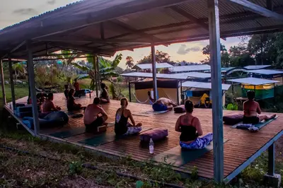 a group of people doing yoga on a wooden deck at Rainforest Glamping, Forest Bathing in the Osa Region in Ciudad Cortés