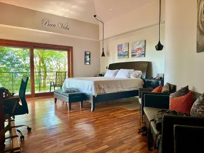 a bedroom with a bed and a living room at Luxurious Rainforest Retreat in Drake Bay, Osa, Costa Rica in Drake