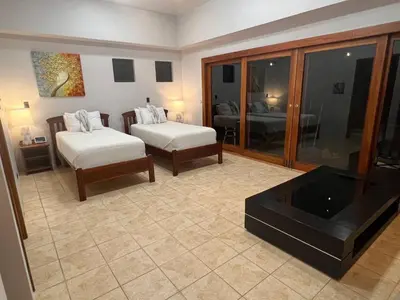 a living room with two beds and a flat screen tv at Luxurious Rainforest Retreat in Drake Bay, Osa, Costa Rica in Drake