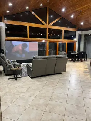 a living room with a large screen in a building at Luxurious Rainforest Retreat in Drake Bay, Osa, Costa Rica in Drake