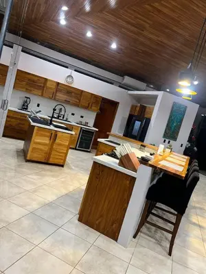 a large kitchen with wooden cabinets and a table at Luxurious Rainforest Retreat in Drake Bay, Osa, Costa Rica in Drake
