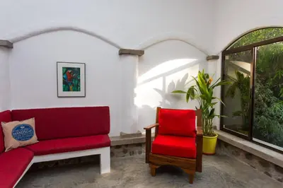 a living room with a red couch and a red chair at Villa Lapas and Apartment, Central, Pool and lots of Wildlife in Manuel Antonio
