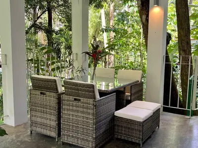 a porch with wicker chairs and a table with at Villa Lapas and Apartment, Central, Pool and lots of Wildlife in Manuel Antonio