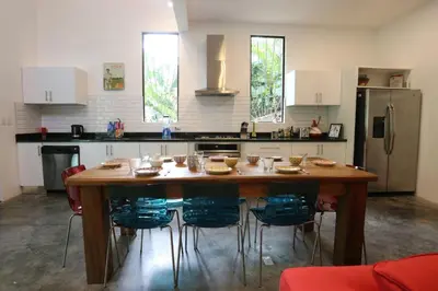 a kitchen with a wooden table with chairs and a refrigerator at Villa Lapas and Apartment, Central, Pool and lots of Wildlife in Manuel Antonio