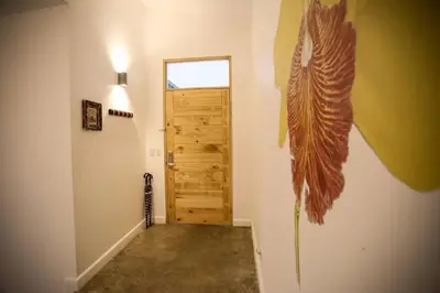a hallway with a door with a feather on the wall at Villa Lapas and Apartment, Central, Pool and lots of Wildlife in Manuel Antonio