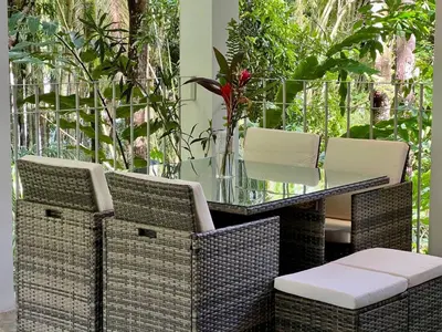 a glass table with wicker chairs and a tableasteryasteryasteryasteryasteryastery at Villa Lapas and Apartment, Central, Pool and lots of Wildlife in Manuel Antonio