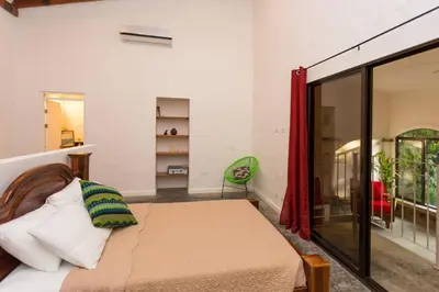 a bedroom with a bed in a room with a window at Villa Lapas and Apartment, Central, Pool and lots of Wildlife in Manuel Antonio
