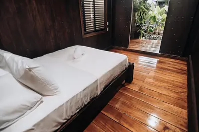 a large bed in a room with a wooden floor at El Carpintero Guest House in Fortuna