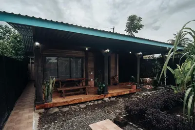 a house with a wooden porch with a bench at El Carpintero Guest House in Fortuna