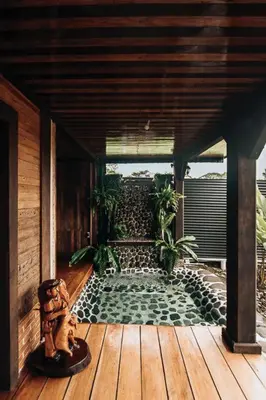 a patio with a pond on a wooden deck at El Carpintero Guest House in Fortuna