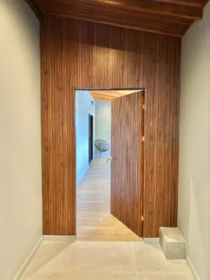 a hallway with a wooden wall and a door at NulaKai Boutique Apartments in Santa Teresa Beach