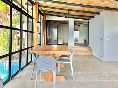 a dining room with a wooden table and chairs at NulaKai Boutique Apartments in Santa Teresa Beach