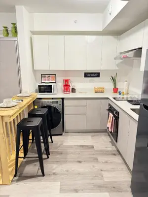 a kitchen with white cabinets and black stools at Original Studio ESCALANTE in San José