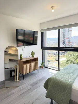 a bedroom with a bed and a large window at Original Studio ESCALANTE in San José