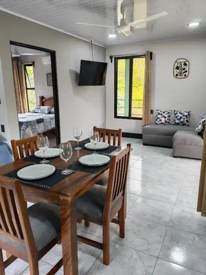 a dining room and living room with a table and chairs at Kalegio Lodge Full Furnished Apartments in Manuel Antonio