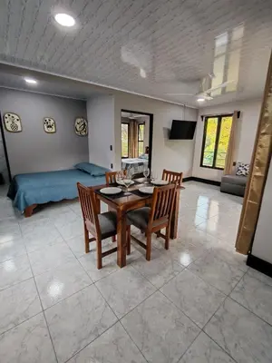 a living room with a table and chairs and a bed at Kalegio Lodge Full Furnished Apartments in Manuel Antonio