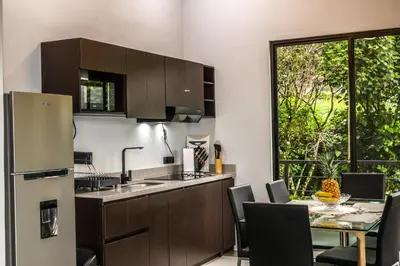 a kitchen and dining room with a table and a refrigerator at Villa Centinela in Monteverde Costa Rica