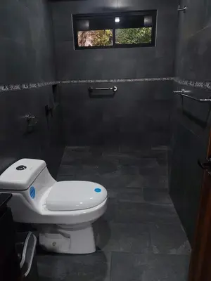 a bathroom with a toilet and a window at Villa Centinela in Monteverde Costa Rica