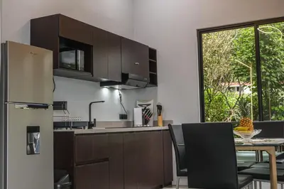 a kitchen with a refrigerator and a table with chairs at Villa Centinela in Monteverde Costa Rica