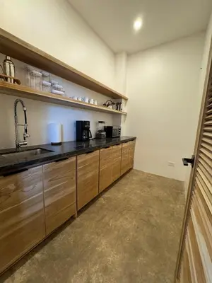 a kitchen with wooden cabinets and a sink at Modern 4BR with Pool, Walk2Beach, Yoga Deck, Sleeps 14 in Nosara