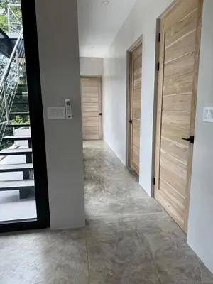 a hallway with two wooden doors and stairs at Modern 4BR with Pool, Walk2Beach, Yoga Deck, Sleeps 14 in Nosara