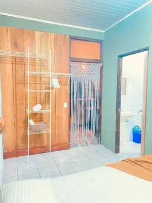 a room with a bedroom with a shower and a door at Rous place# 2 in Fortuna