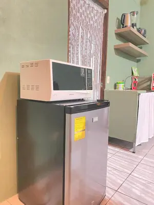 a microwave sitting on top of a refrigerator at Rous place# 2 in Fortuna