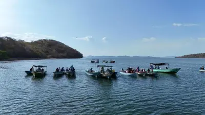 a group of boats in a large body of water at Teak house in a forest above the beach
