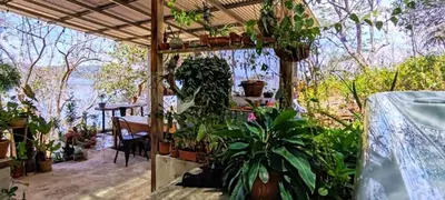 a patio with plants and a table and a table at Teak house in a forest above the beach