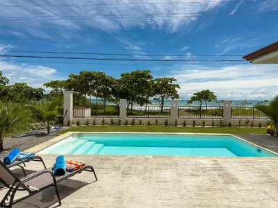 a swimming pool with two chairs next to a fence at Playa Hermosa 44 - Beach House Getaway in Playa Hermosa