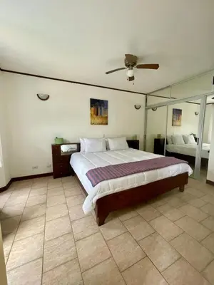 a bedroom with a large bed and a mirror at Beachfront apartment in Jacó in Tapantí