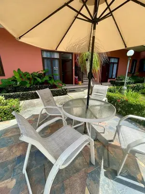 a table and chairs with an umbrella on a patio at Beachfront apartment in Jacó in Tapantí
