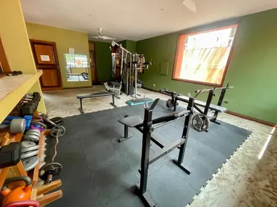 a gym with exercise equipment in a green room at Beachfront apartment in Jacó in Tapantí