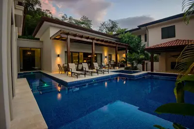 a swimming pool in front of a house at Casa Aurora 5 bdr private pool in Los Sueños in Herradura