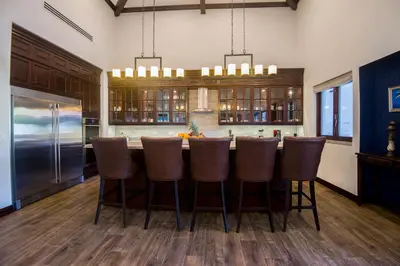 a kitchen with a bar with brown stools at Casa Aurora 5 bdr private pool in Los Sueños in Herradura