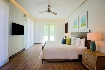 a bedroom with a bed and a flat screen tv at Casa Aurora 5 bdr private pool in Los Sueños in Herradura