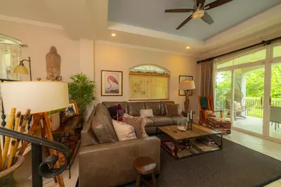 a living room with a couch and a table at Colina 8E 2 bdr Garden View in Los Suenos in Herradura