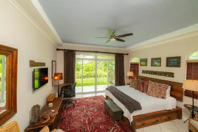 a bedroom with a bed and a large window at Colina 8E 2 bdr Garden View in Los Suenos in Herradura