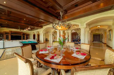 a dining room with a wooden table and a pool table at Casa Garmus 10 bdrs ocean views in Los Suenos in Herradura