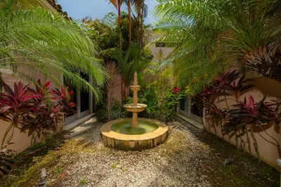 a garden with a fountain in the middle of a building at Casa Garmus 10 bdrs ocean views in Los Suenos in Herradura