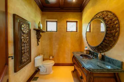 a bathroom with a sink and a mirror and a toilet at Casa Garmus 10 bdrs ocean views in Los Suenos in Herradura