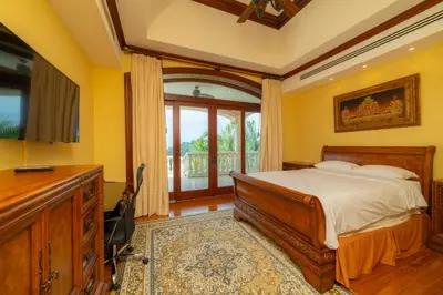 a bedroom with yellow walls and a bed with a desk at Casa Garmus 10 bdrs ocean views in Los Suenos in Herradura