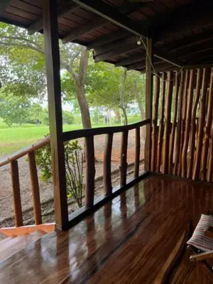 a porch with a wooden floor and a large window at La Ensenada Lodge in Abangaritos