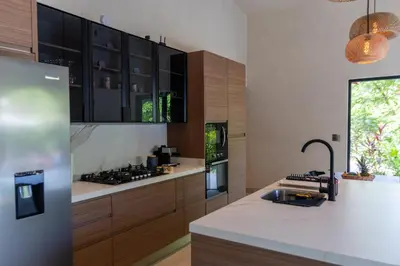 a kitchen with wooden cabinets and a counter top at Nakama Nosara in Nicoya