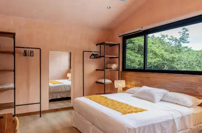 a bedroom with a bed and a large window at Nakama Nosara in Nicoya