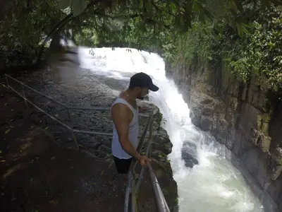 a man is standing next to a waterfall at Charming Small House, Near the beach & Waterfalls in Platanillo